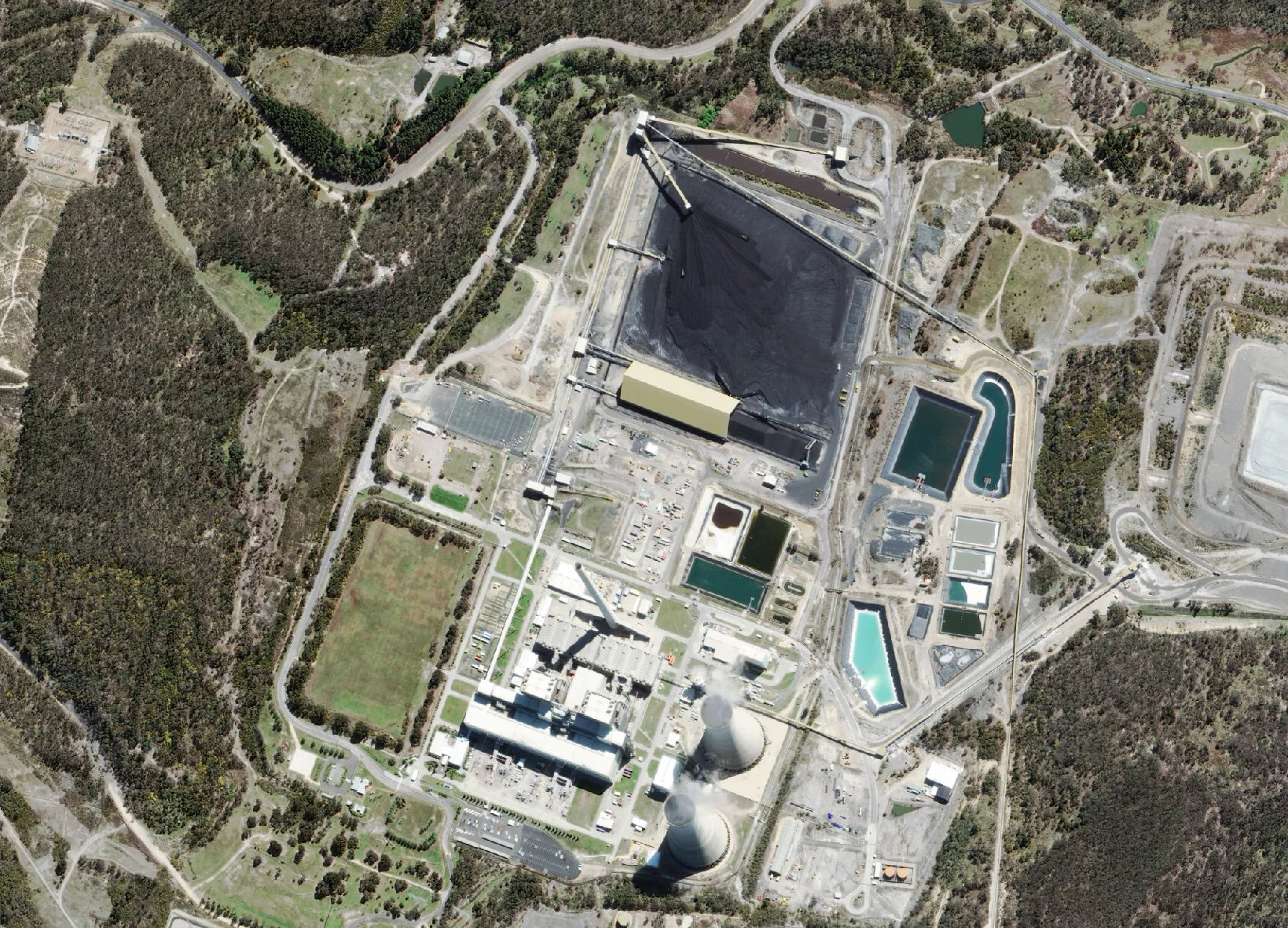 Custom satellite mosaic of a coal-fired power station, coal stockpile and water storage ponds