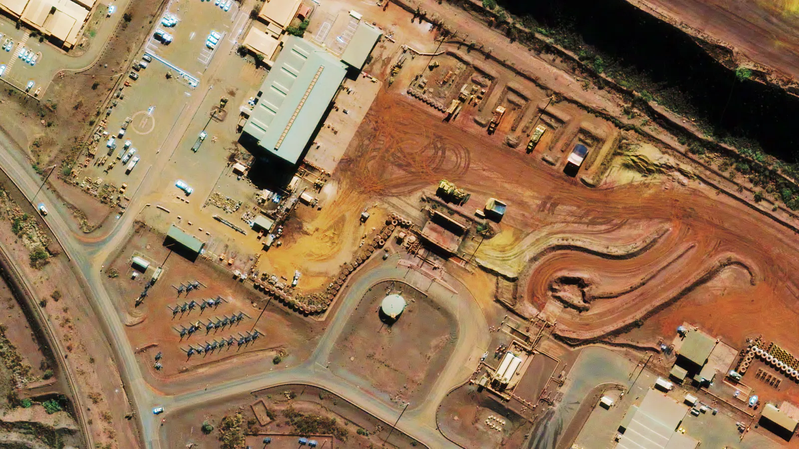 Orthorectified 30cm satellite image of a mine site with buildings, a rail line and equipment laydown areas positioned for measurement