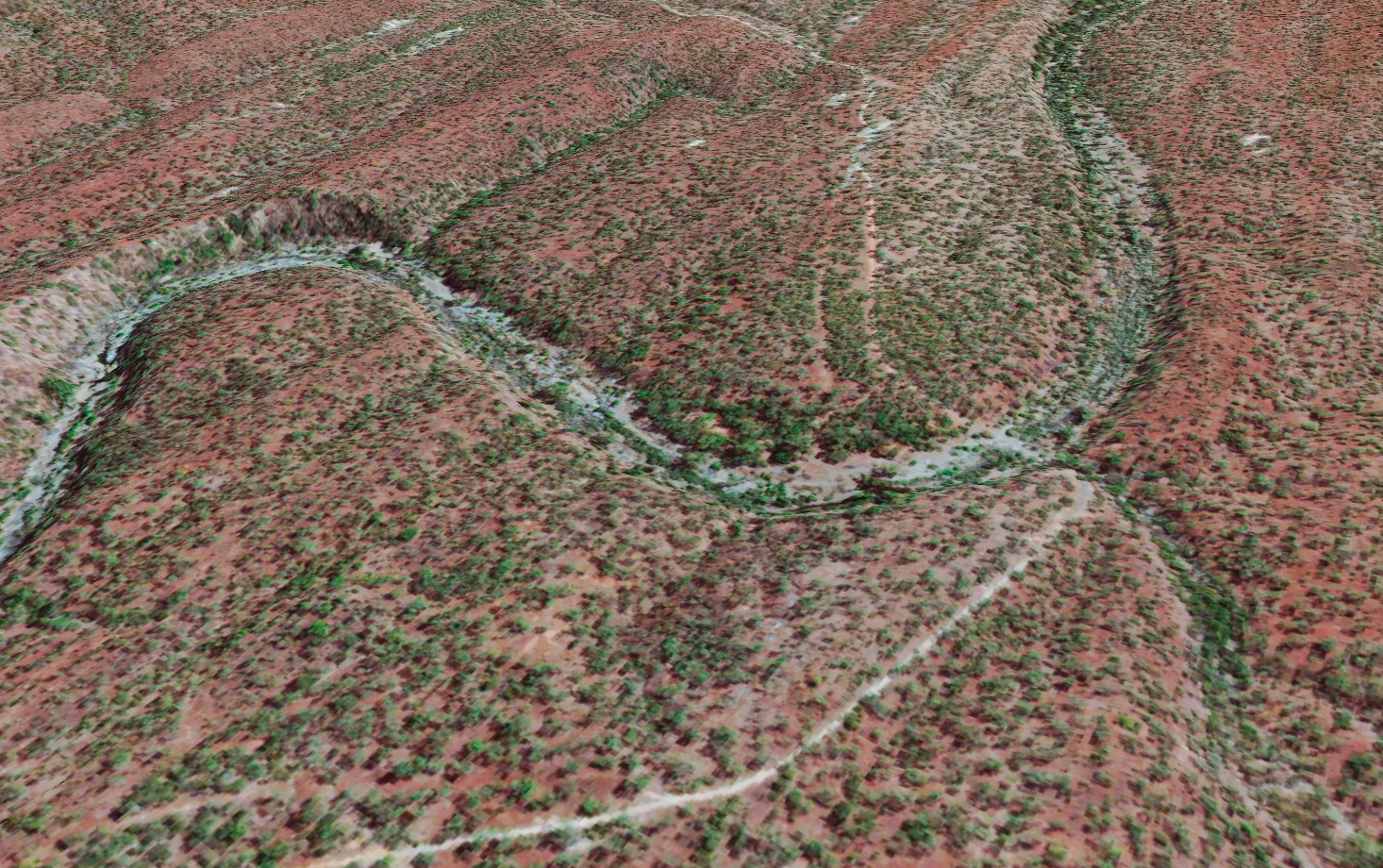 Oblique 3D view of 30cm satellite imagery showing an incised creek bend and an unsealed track through red soil and scattered scrub