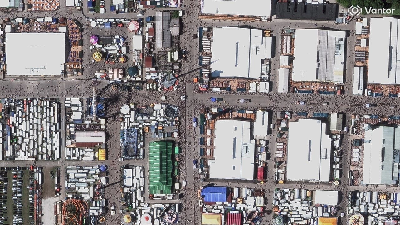 Vantor 30 cm archive satellite imagery of Oktoberfest in Munich showing individual tents, vehicles, and crowd detail.