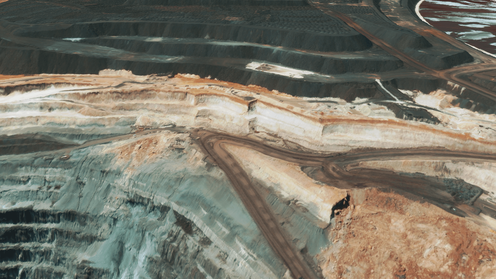 3D elevation model showing mine benches, haul roads and geological stratification.